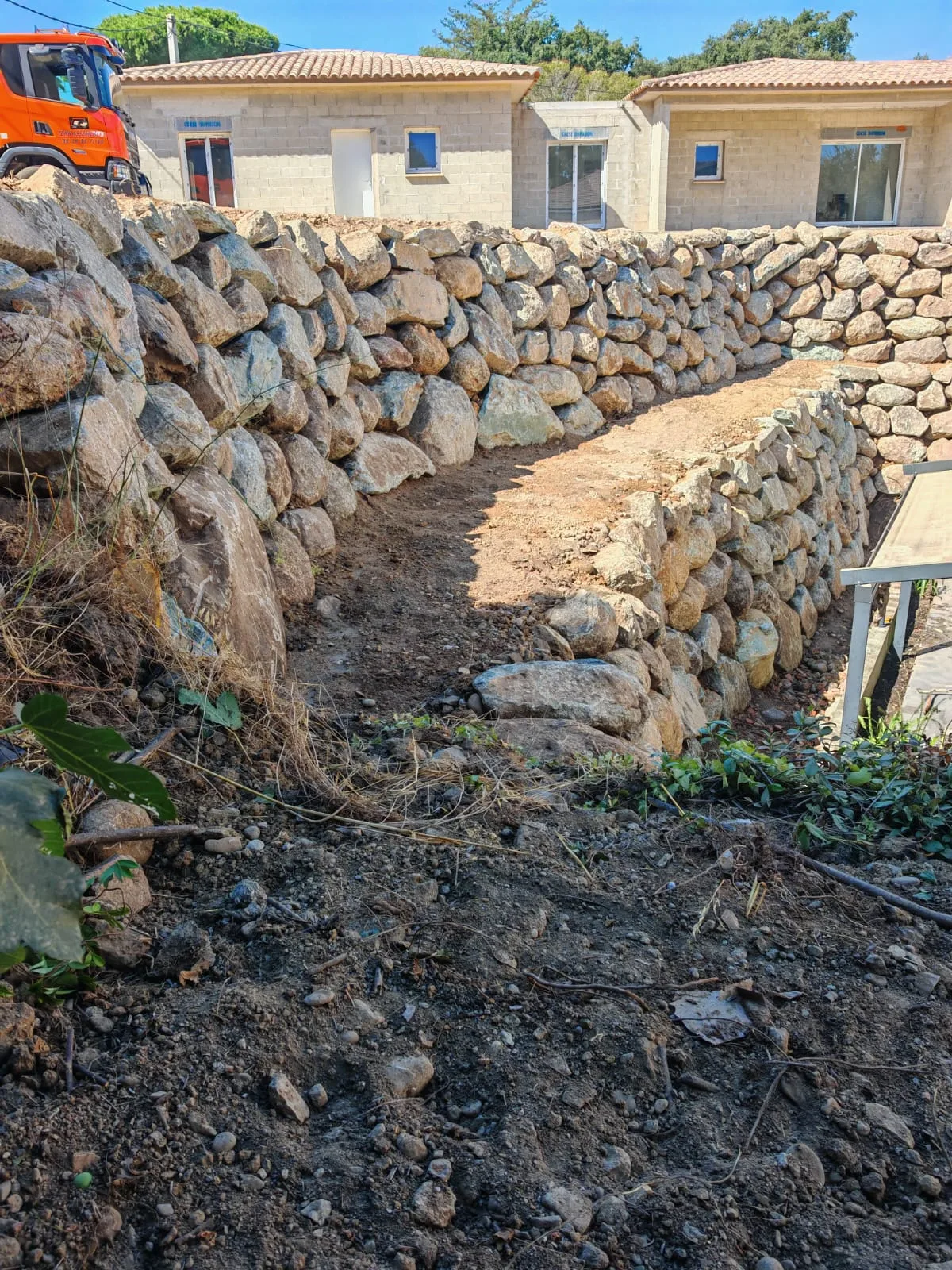 Création d'un mur de soutènement en enrochement sur deux paliers.